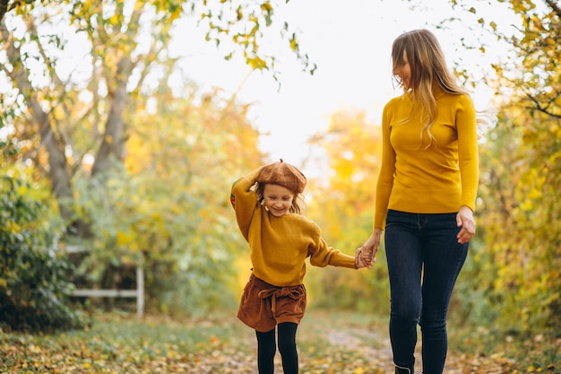 Giovane madre con la sua piccola figlia in un parco in autunno