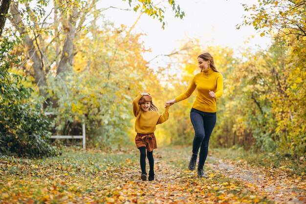 Young mother with her little daughter in an autumn park