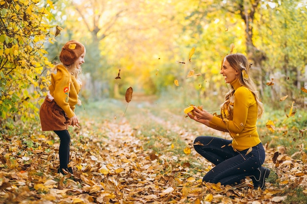 Young mother with her little daughter in an autumn park