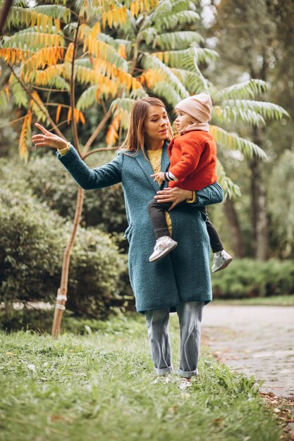 Young mother with her little daughter in an autumn park