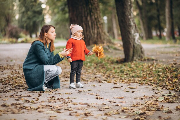 秋の公園で幼い娘と若い母親