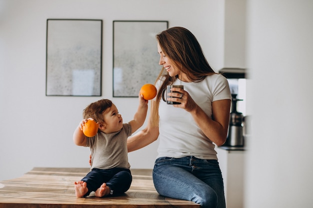 Free photo young mother with little son drinking water at home