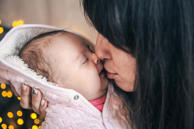 生まれたばかりの女の赤ちゃんを腕に抱えた若い母親