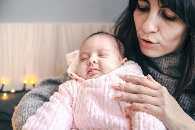 A young mother with a newborn baby girl in her arms