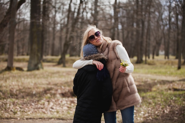 Young mother with sunglasses embracing her son