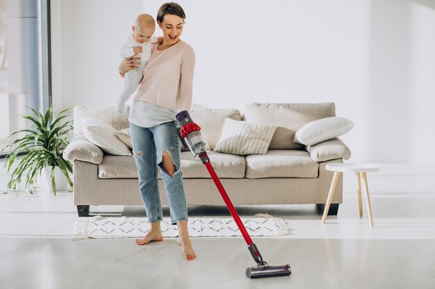 Young mother with toddler son cleaning up at home