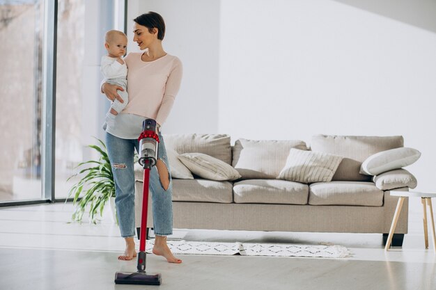 Young mother with toddler son cleaning up at home