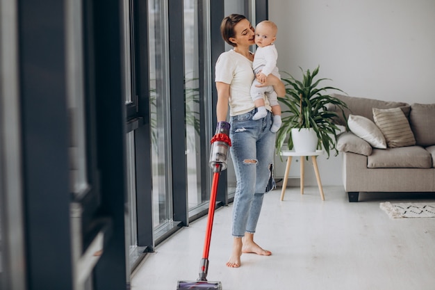 Young mother with toddler son cleaning up at home