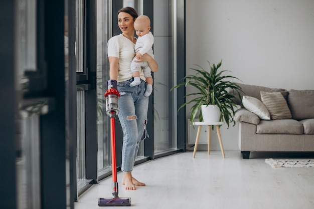 Young mother with toddler son cleaning up at home