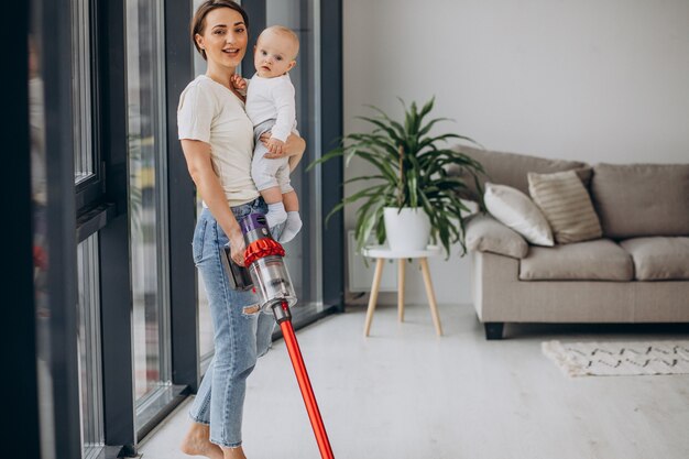 Young mother with toddler son cleaning up at home