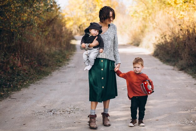 Young mother with two sons walking in park