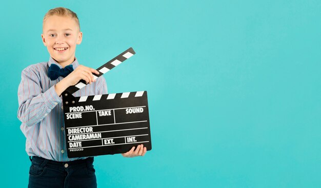 Young movie director holding clapperboard