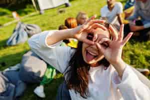 Free photo young multi ethnic group of people watching movie at poof in open air cinema close up portrait of funny girl