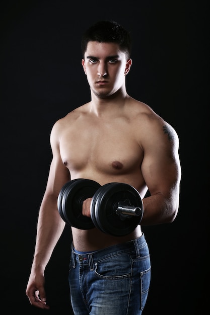 Young and muscular guy with dumbbell