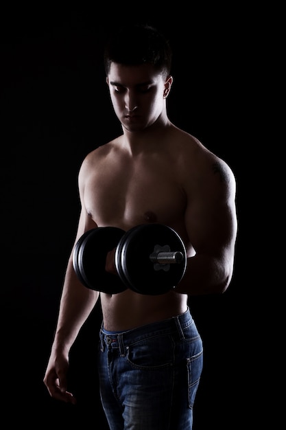 Young and muscular guy with dumbbell