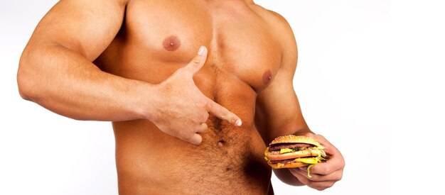 Young muscular man holding a hamburger