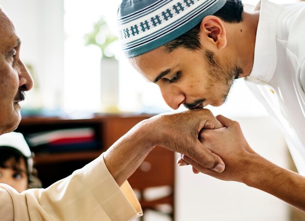 Young Muslim man showing respect to his father