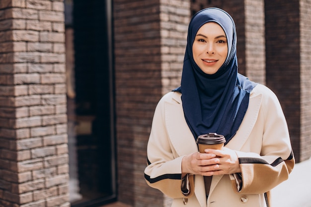 Young muslim woman drinking coffee