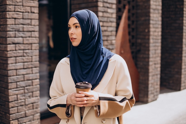 Foto gratuita giovane donna musulmana che beve caffè