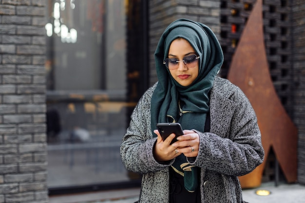 Young muslim woman looking in a smartphone