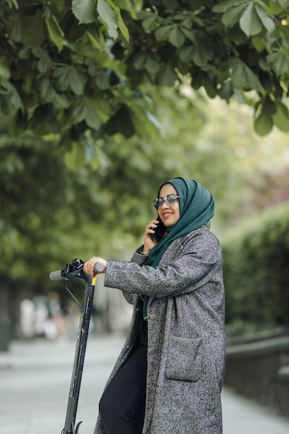 通りでスクーターに乗って若いイスラム教徒の女性