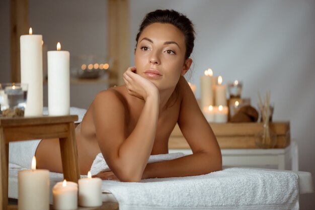 Young naked woman relaxing in spa salon.