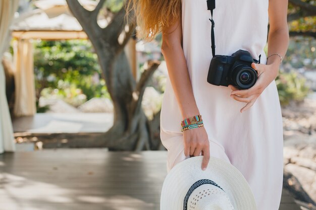 Young natural beautiful woman in pale gown posing, tropical vacation, straw hat, holding sensual, summer outfit, resort, boho vintage style,  close-up, details, hands