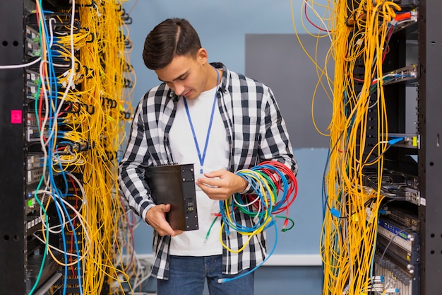 Молодой сетевой инженер смотрит на коммутаторы Ethernet