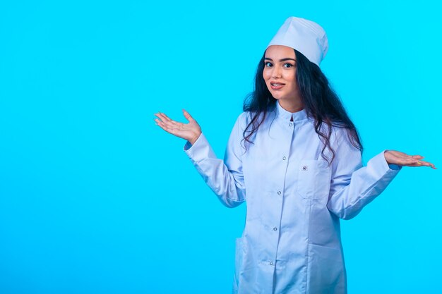 Young nurse in isolated uniform looks positive