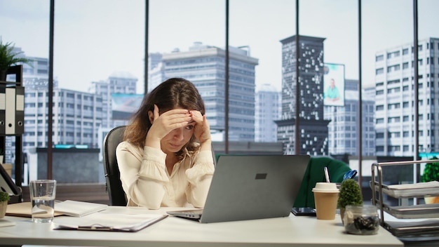 Young overburdened CEO dealing with a headache and working under pressure