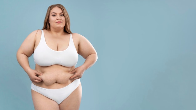 Young oversized woman posing in white lingerie