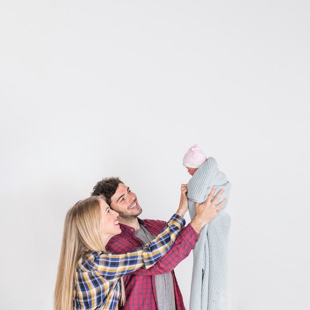 Free photo young parents looking at baby in hands