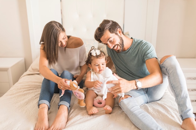 Young parents showing toys to daughter