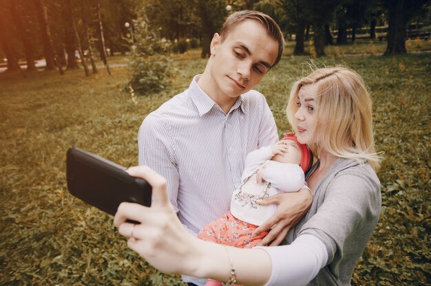 Молодые родители, принимая фотографии со своим ребенком