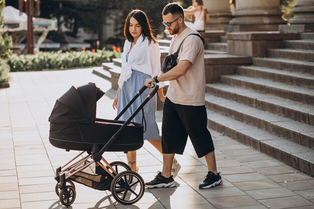 Young parents walking with their baby in a stroller