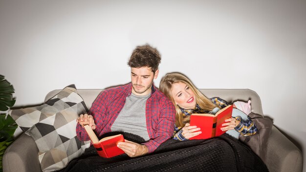 Young parents with baby reading books