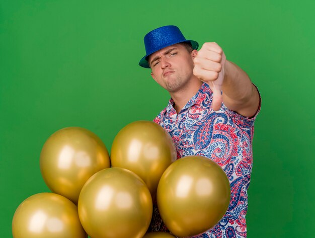 Young party guy wearing blue hat isolated on green