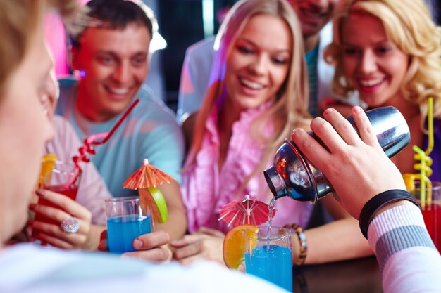 Young people drinking cocktails at nightclub