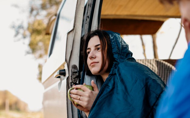 Young people drinking coffee inside their van