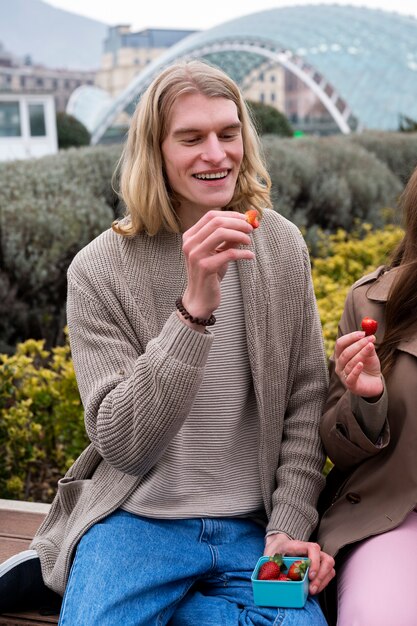 Young people eating berries in the street