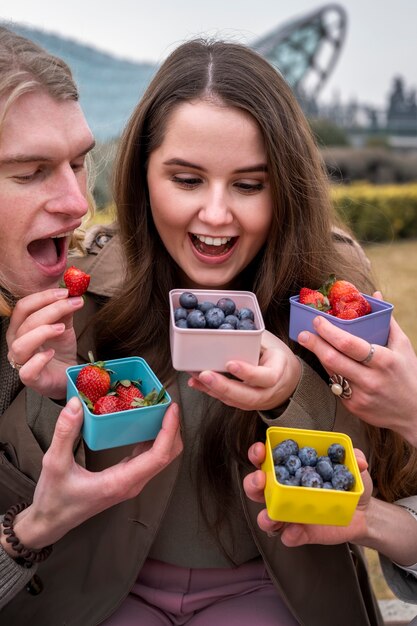 Young people eating berries in the street