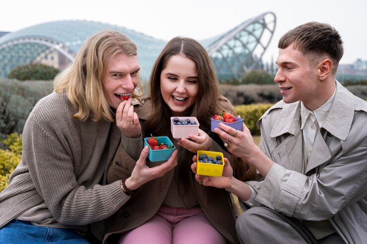 Young people eating berries in the street