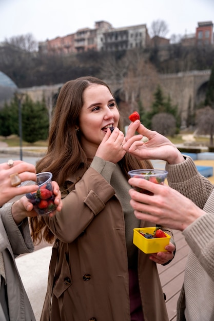 Молодые люди едят ягоды на улице