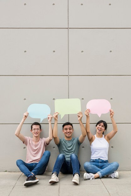 Young people holding colorful speech bubbles