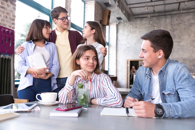 Foto gratuita giovani seduti nella caffetteria