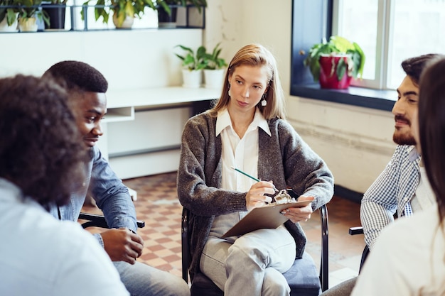 Young people sitting in a circle and having a discussion Free Photo