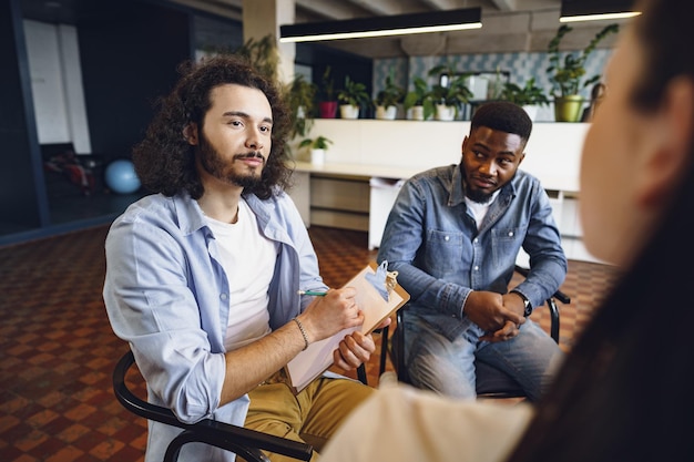 Free photo young people sitting in a circle and having a discussion