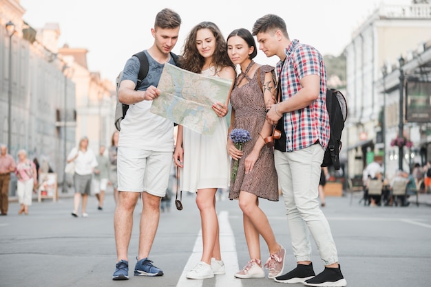Young people standing on street discovering city map