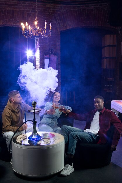 Young people vaping from a hookah in a bar