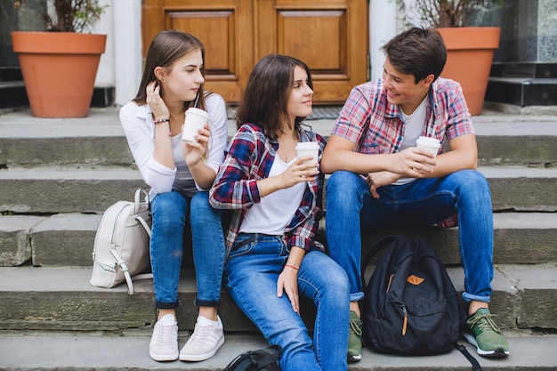 Young people with coffee on stairs